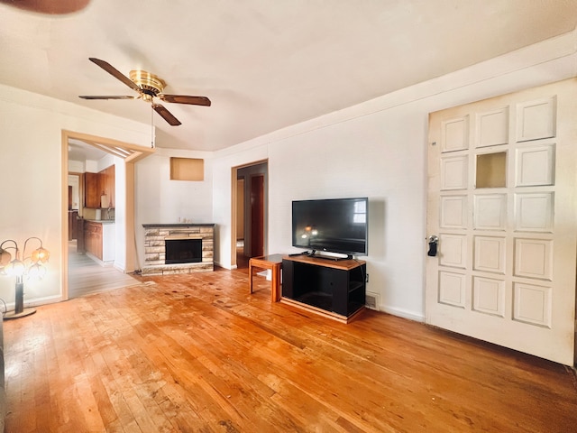 20760 Atlantic Ave, Warren, MI 48091 - unfurnished living room with hardwood / wood-style floors, ceiling fan, a stone fireplace, and baseboards