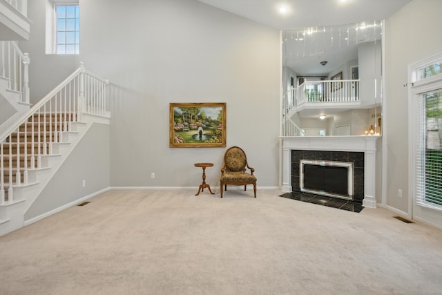 17280 Breckenridge Dr, Clinton Township, MI 48038 - living area with a high ceiling, a tiled fireplace, stairway, carpet floors, and baseboards
