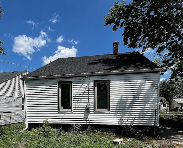 8855 Vaughan St, Detroit, MI 48228 - view of side of home featuring a chimney, fence, and roof with shingles
