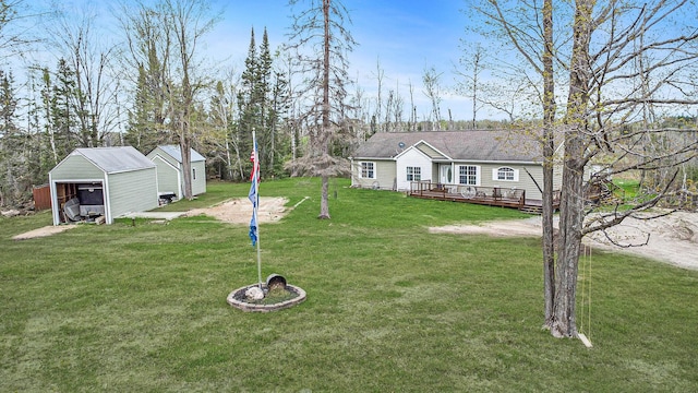 19378 Hackett Lake Highway, Onaway, MI 49765 - view of green lawn with a deck, an outbuilding, and a garage