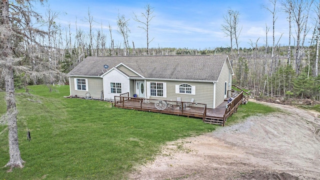 19378 Hackett Lake Highway, Onaway, MI 49765 - view of front facade with a wooden deck, a front yard, roof with shingles, and dirt driveway