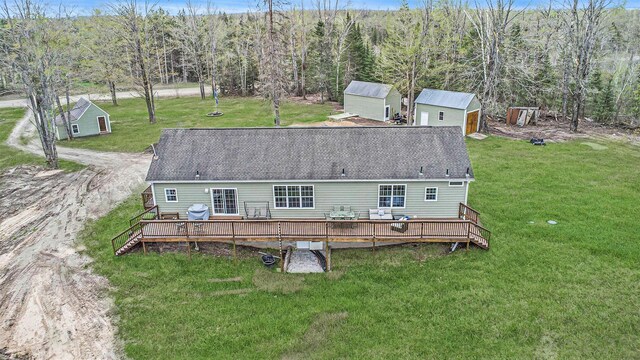 19378 Hackett Lake Highway, Onaway, MI 49765 - back of property with a storage unit, a wooden deck, an outbuilding, and a lawn