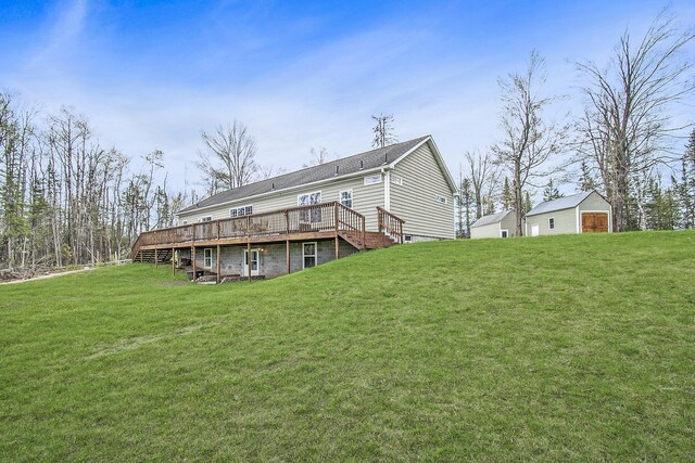 19378 Hackett Lake Highway, Onaway, MI 49765 - back of house featuring a wooden deck, a yard, and an outdoor structure