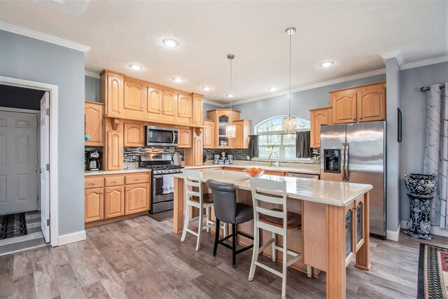19378 Hackett Lake Highway, Onaway, MI 49765 - kitchen with stainless steel appliances, ornamental molding, backsplash, light countertops, and a kitchen island