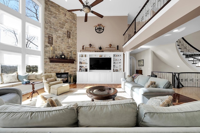 5001 Forest Vly, Clarkston, MI 48348 - living room featuring high vaulted ceiling, ceiling fan, wood finished floors, ornate columns, and stairway