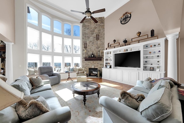 5001 Forest Vly, Clarkston, MI 48348 - living area with ornate columns, a high ceiling, a ceiling fan, a fireplace, and light wood-style flooring