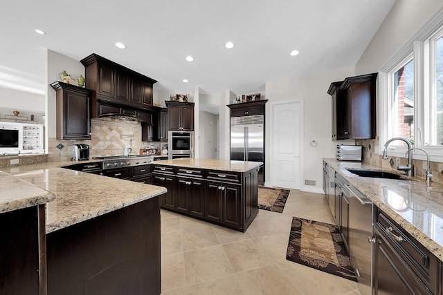 5001 Forest Vly, Clarkston, MI 48348 - kitchen with appliances with stainless steel finishes, a sink, custom range hood, decorative backsplash, and light stone countertops