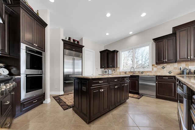 5001 Forest Vly, Clarkston, MI 48348 - kitchen with appliances with stainless steel finishes, tasteful backsplash, a sink, light stone counters, and recessed lighting