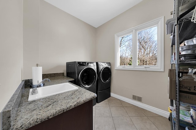 5001 Forest Vly, Clarkston, MI 48348 - laundry room with washer and clothes dryer, baseboards, and light tile patterned floors