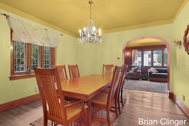 117 Palmer St NE, Grand Rapids, MI 49505 - dining room with arched walkways, wood finished floors, a chandelier, and baseboards