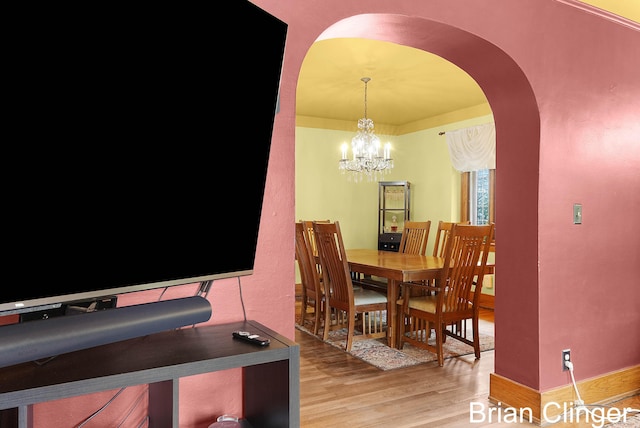 117 Palmer St NE, Grand Rapids, MI 49505 - dining room featuring light wood-style flooring, arched walkways, a chandelier, and baseboards