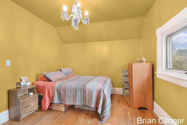 117 Palmer St NE, Grand Rapids, MI 49505 - bedroom with a chandelier, vaulted ceiling, wood finished floors, and baseboards