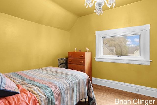 117 Palmer St NE, Grand Rapids, MI 49505 - bedroom featuring wood finished floors, baseboards, vaulted ceiling, and a chandelier