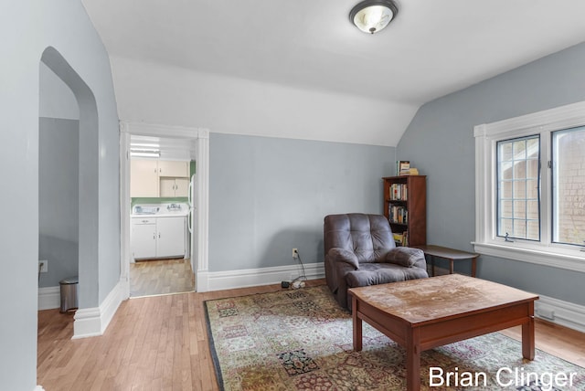 117 Palmer St NE, Grand Rapids, MI 49505 - sitting room featuring light wood-type flooring, vaulted ceiling, baseboards, and arched walkways