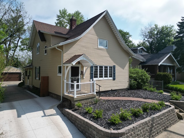 117 Palmer St NE, Grand Rapids, MI 49505 - view of front of property featuring an outdoor structure, a chimney, fence, a shingled roof, and a detached garage