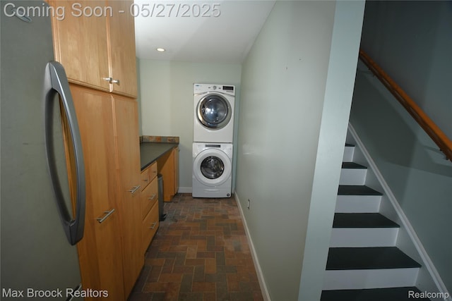 58282 Savage Rd, Vandalia, MI 49095 - washroom with estacked washer and dryer, cabinet space, baseboards, and brick patterned flooring