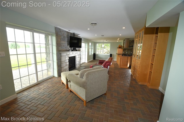 58282 Savage Rd, Vandalia, MI 49095 - living area with baseboards, a stone fireplace, brick patterned floors, and recessed lighting