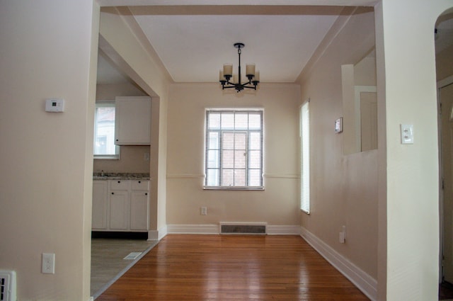 5790 Lakepointe St, Detroit, MI 48224 - unfurnished dining area featuring a chandelier, wood finished floors, and baseboards
