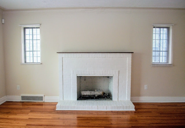 5790 Lakepointe St, Detroit, MI 48224 - detailed view of wood finished floors, a brick fireplace, crown molding, and baseboards