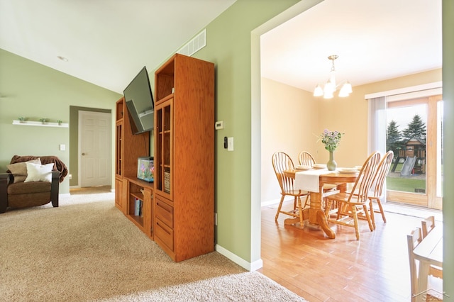 6115 N Belsay Rd, Flint, MI 48506 - dining space featuring a chandelier, baseboards, lofted ceiling, and light wood-style floors