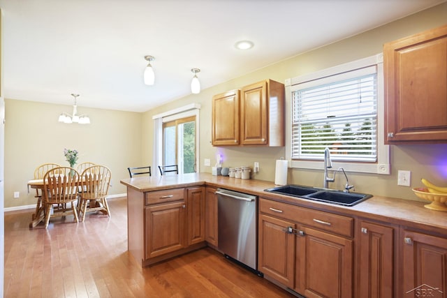 6115 N Belsay Rd, Flint, MI 48506 - kitchen with stainless steel dishwasher, a sink, a peninsula, light countertops, and light wood-style floors