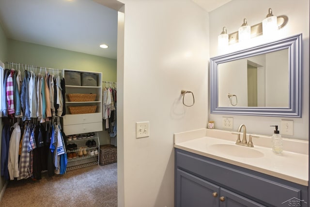 6115 N Belsay Rd, Flint, MI 48506 - bathroom with vanity, a walk in closet, and recessed lighting