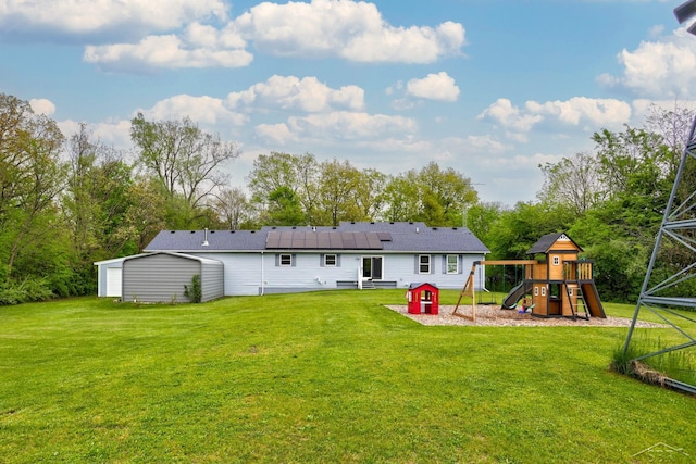 6115 N Belsay Rd, Flint, MI 48506 - back of house featuring a playground, solar panels, and a yard