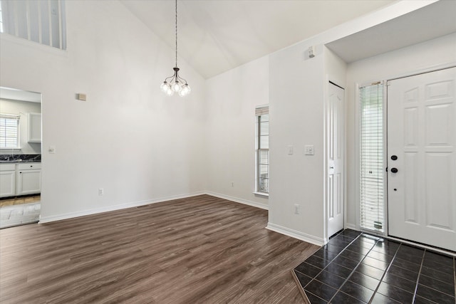 5496 Michael Dr, Ypsilanti, MI 48197 - foyer entrance featuring a chandelier, dark wood finished floors, high vaulted ceiling, and baseboards