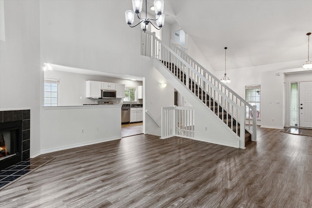 5496 Michael Dr, Ypsilanti, MI 48197 - unfurnished living room with a chandelier, stairs, high vaulted ceiling, and healthy amount of natural light