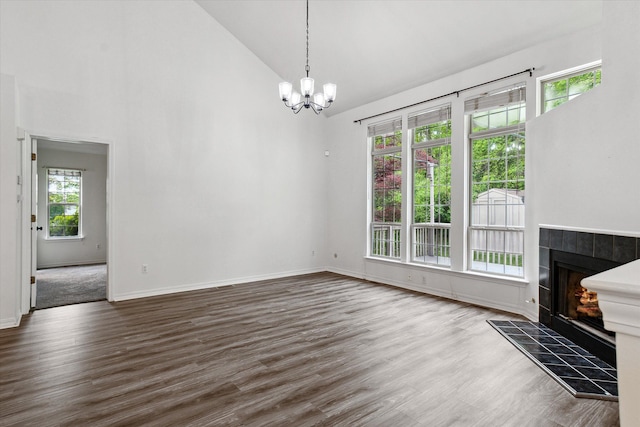5496 Michael Dr, Ypsilanti, MI 48197 - unfurnished living room with a chandelier, high vaulted ceiling, a fireplace, wood finished floors, and baseboards