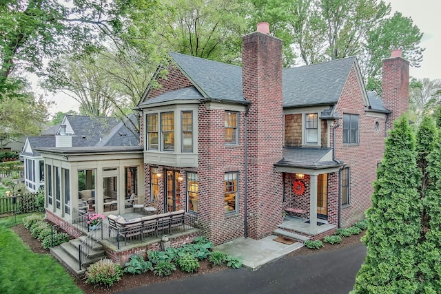 316 Chesterfield Ave, Birmingham, MI 48009 - rear view of property featuring a sunroom, a chimney, brick siding, and a shingled roof