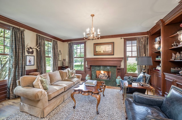 316 Chesterfield Ave, Birmingham, MI 48009 - living room with a chandelier, wood finished floors, a premium fireplace, crown molding, and a wainscoted wall