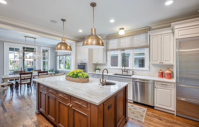 316 Chesterfield Ave, Birmingham, MI 48009 - kitchen featuring stainless steel appliances, a sink, ornamental molding, white cabinetry, and a kitchen island with sink