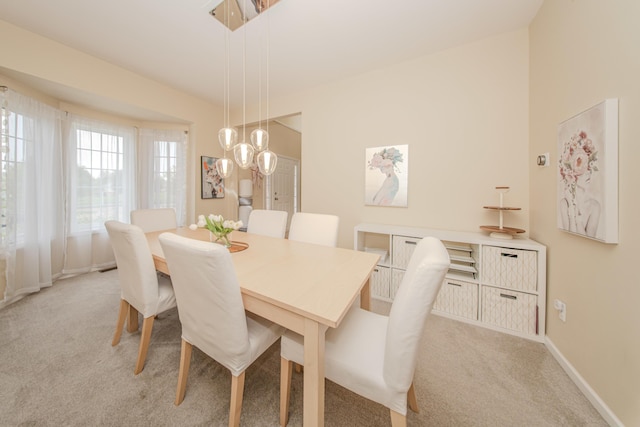 57677 Blossom Valley Trl, New Hudson, MI 48165 - dining space featuring light carpet, baseboards, and a chandelier