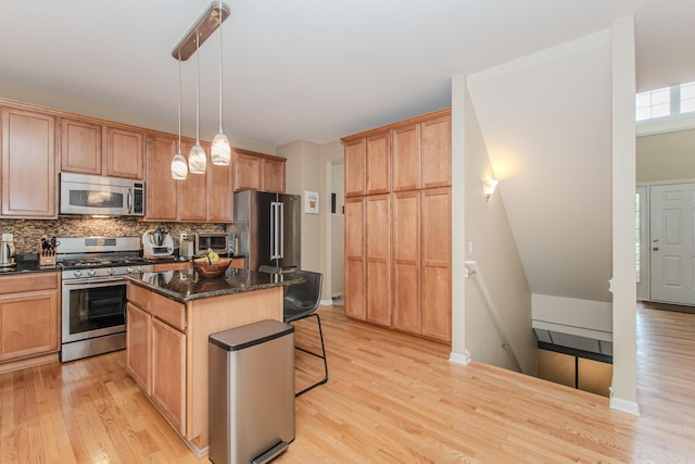 57677 Blossom Valley Trl, New Hudson, MI 48165 - kitchen featuring appliances with stainless steel finishes, light wood-style flooring, a breakfast bar, and a center island