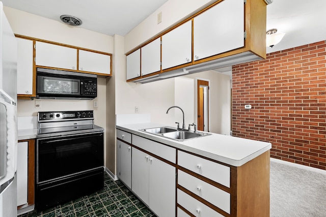 8118 Bruning St, Portage, MI 49002 - kitchen featuring black appliances, a sink, brick wall, light countertops, and white cabinets