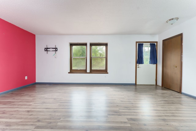 4384 Dexter Pinckney Rd, Dexter, MI 48130 - unfurnished room with wood finished floors, baseboards, and a textured ceiling