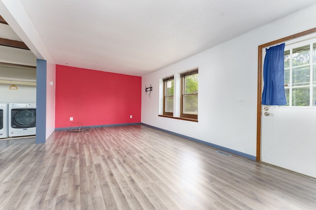 4384 Dexter Pinckney Rd, Dexter, MI 48130 - unfurnished living room featuring separate washer and dryer, healthy amount of natural light, and wood finished floors
