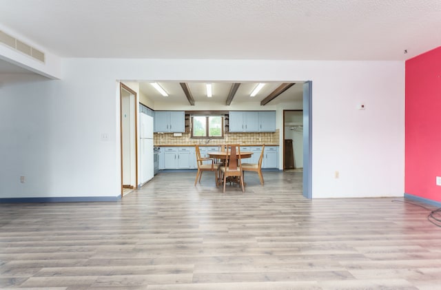 4384 Dexter Pinckney Rd, Dexter, MI 48130 - kitchen featuring light wood-style floors, freestanding refrigerator, and backsplash