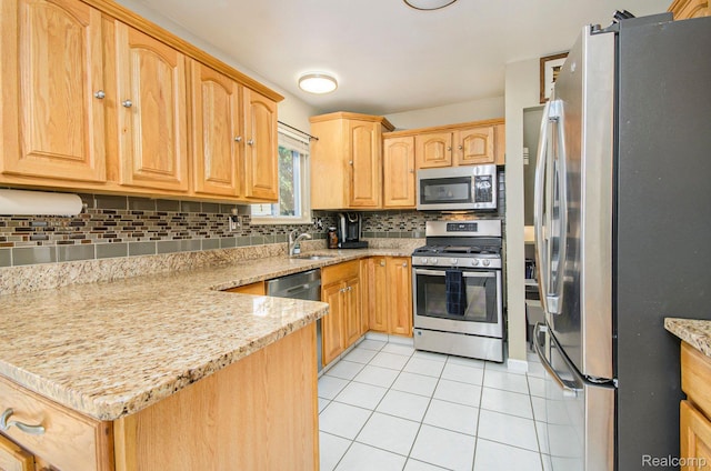 2426 Camel Dr, Sterling Heights, MI 48310 - kitchen featuring appliances with stainless steel finishes, light tile patterned floors, a sink, tasteful backsplash, and light stone countertops