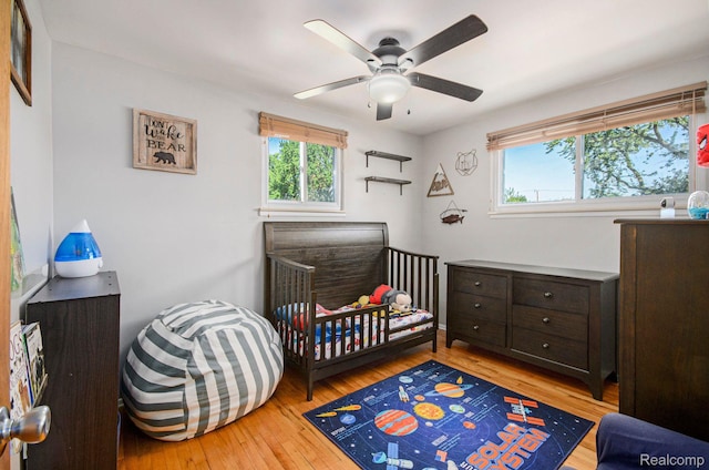 2426 Camel Dr, Sterling Heights, MI 48310 - bedroom featuring wood-type flooring, a ceiling fan, and a crib