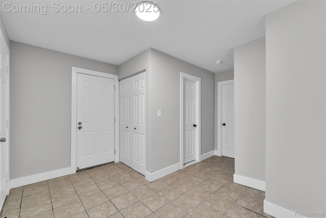 22929 Wrexford Dr, Southfield, MI 48033 - unfurnished bedroom with baseboards, light tile patterned flooring, and a closet