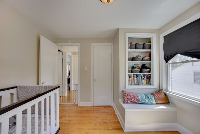 hall featuring light wood-style floors and baseboards