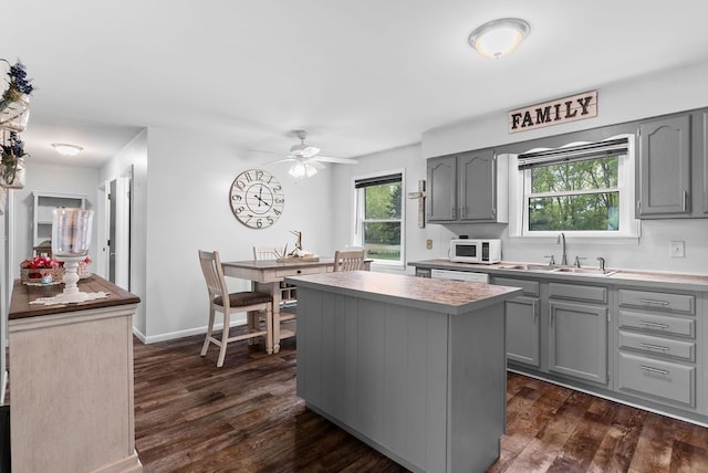 19354 Bueche Rd, New Lothrop, MI 48460 - kitchen featuring gray cabinets, a sink, white appliances, and a kitchen island