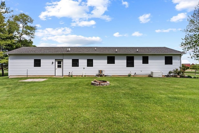 19354 Bueche Rd, New Lothrop, MI 48460 - back of property with a fire pit, a yard, and a shingled roof