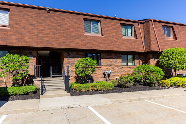 38554 Lanse Creuse St, Harrison Township, MI 48045 - view of front of home featuring brick siding, mansard roof, uncovered parking, and a shingled roof