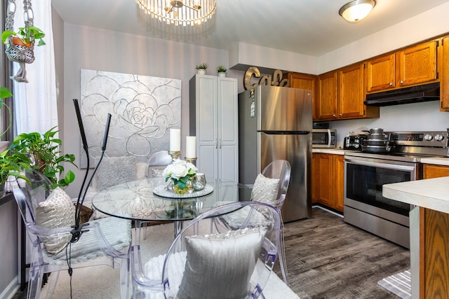 38554 Lanse Creuse St, Harrison Township, MI 48045 - kitchen featuring appliances with stainless steel finishes, light countertops, brown cabinets, under cabinet range hood, and dark wood-style flooring