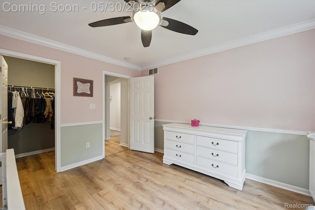 326 Redmaple Ln, Brighton, MI 48116 - unfurnished bedroom featuring a walk in closet, crown molding, a closet, light wood finished floors, and baseboards