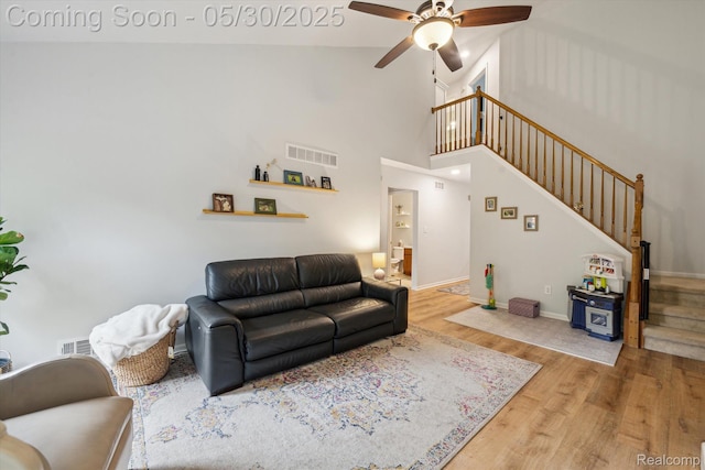 326 Redmaple Ln, Brighton, MI 48116 - living area with stairway, wood finished floors, a ceiling fan, baseboards, and high vaulted ceiling