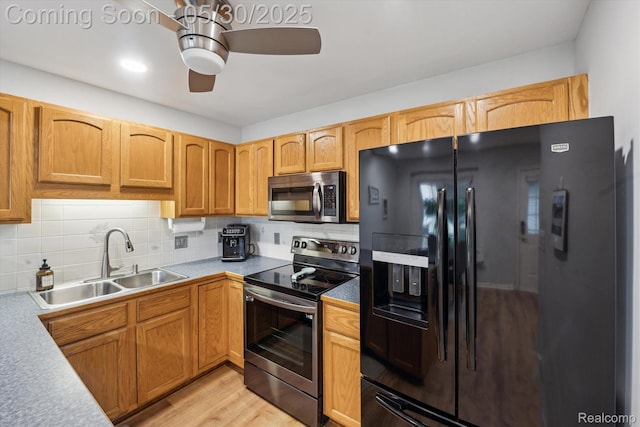 326 Redmaple Ln, Brighton, MI 48116 - kitchen featuring appliances with stainless steel finishes, a sink, ceiling fan, tasteful backsplash, and light wood-style floors